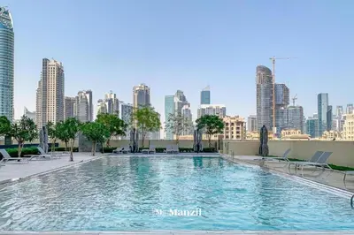 a large swimming pool with a city skyline in the background at Luxury 2BR Apartment in Downtown with Full Burj Khalifa View in Dubai
