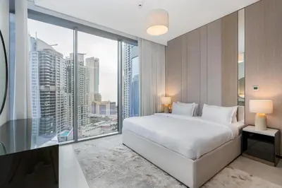 a bedroom with a white bed and a large window at Bespoke Holiday Homes - Luxury 2BR with Stunning Marina Views in LIV Marina in Dubai