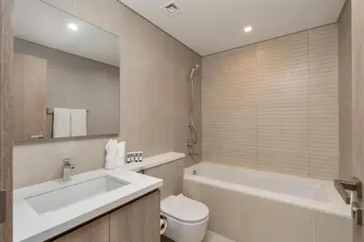 a bathroom with a tub and a toilet and a sink at Bespoke Holiday Homes - Luxury 2BR with Stunning Marina Views in LIV Marina in Dubai
