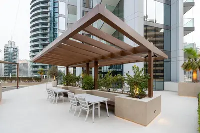awning on the roof of a building with tables and chairs at Bespoke Holiday Homes - Luxury 2BR with Stunning Marina Views in LIV Marina in Dubai