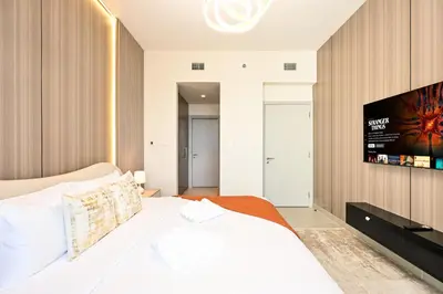 a bedroom with a bed and a flat screen tv at Luxury 2BR in Downtown 35th Floor 5 min walk Dubai Mall, Gym,Pool, 500mbps Wifi, Forte Tower in Dubai