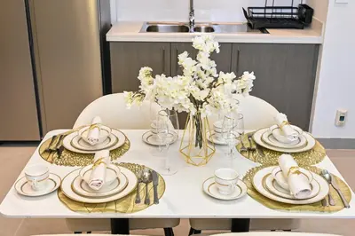 a white table with plates and dishes and flowers on it at Luxury 2BR in Downtown 35th Floor 5 min walk Dubai Mall, Gym,Pool, 500mbps Wifi, Forte Tower in Dubai
