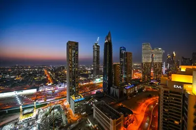 a city lit up at night with traffic at Luxury 2BR in Downtown 35th Floor 5 min walk Dubai Mall, Gym,Pool, 500mbps Wifi, Forte Tower in Dubai