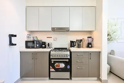 a kitchen with a stove and a microwave at Luxury 2BR in Downtown 35th Floor 5 min walk Dubai Mall, Gym,Pool, 500mbps Wifi, Forte Tower in Dubai