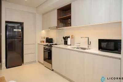 a kitchen with a stainless steel refrigerator and a sink at Brand New Modern 2 BR Retreat in Dubai Creek Harbour in Dubai