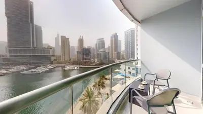 a balcony with chairs and a view of a city at The Point - One Bed with Marina Skyline Views in Dubai