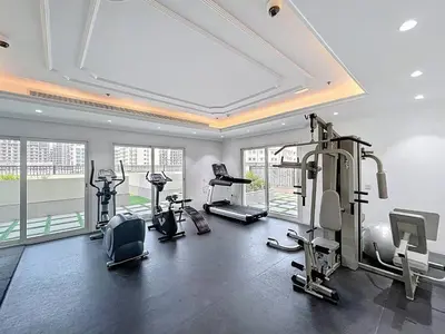 a gym with several treadmills and elliptical machines at Al Ghaf - Upgraded One Bed with Pool View in Arjan in Dubai