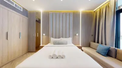 a bedroom with a large white bed and a couch at Azizi Riviera - Chic Studio with Balcony in Meydan in Dubai