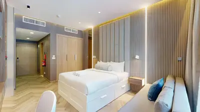 a bedroom with a large white bed and a couch at Azizi Riviera - Chic Studio with Balcony in Meydan in Dubai