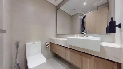 a bathroom with a sink and a toilet and a mirror at Azizi Riviera - Chic Studio with Balcony in Meydan in Dubai