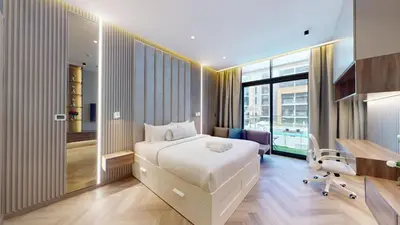 a hotel room with a bed and a desk and a window at Azizi Riviera - Chic Studio with Balcony in Meydan in Dubai