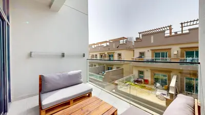 a balcony with a chair and a view of a building at Oxford Boulevard - Vibrant Studio in JVC in Dubai