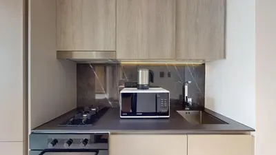 a kitchen with a coffee maker and a microwave at Oxford Boulevard - Vibrant Studio in JVC in Dubai