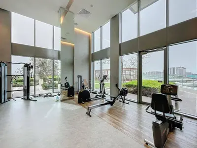 a gym with treadmills and exercise equipment in a building at 5242 Tower 2 - One Bed, Low Floor with Canal View in Dubai