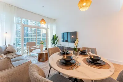 a living room with a table and chairs at Dubai Marina Waterfront Stay with Maid Room in Dubai