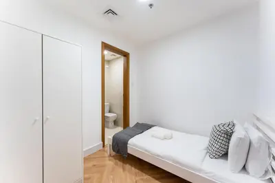 a white room with a bed and a toilet at Dubai Marina Waterfront Stay with Maid Room in Dubai