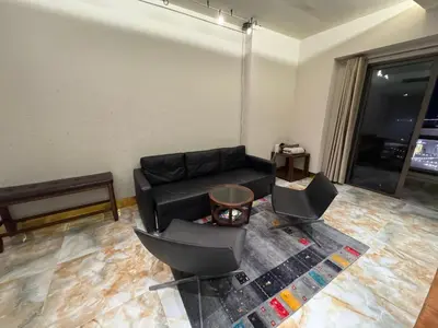 a living room with a black couch and two chairs at Stylish 1BR JBR Beachfront in Dubai