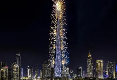 a lit up tower in a city at night at Modern Homestay Oval Tower, Business Bay in Dubai