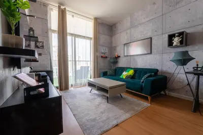 a living room with a green couch and a table at Designer Suite with Skyline views in Dubai
