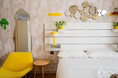 a bedroom with a white bed and a yellow chair at Designer Suite with Skyline views in Dubai