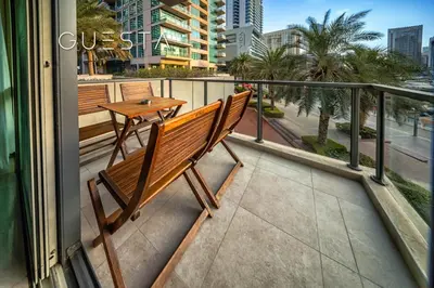 a balcony with a wooden bench and a table at Al Majara 1 BDR plus Guest Bedroom, Dubai Marina in Dubai