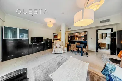a living room with a table and a dining room at Al Majara 1 BDR plus Guest Bedroom, Dubai Marina in Dubai