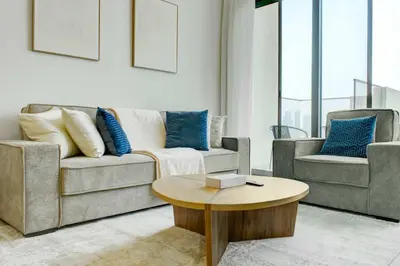 a living room with a couch and a table at TRPS - Farhad Azizi, Al Jaddaf - Premium 1BR, Furnished with Pool View in Dubai