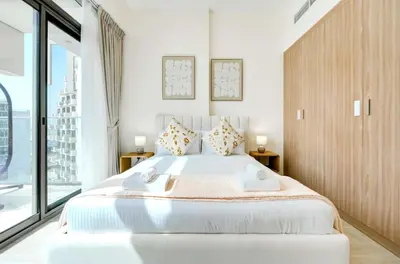 a bedroom with a large white bed with a large window at TRPS - Farhad Azizi, Al Jaddaf - Premium 1BR, Furnished with Pool View in Dubai