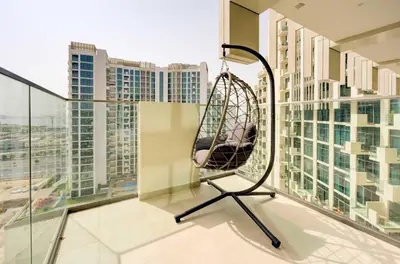 a chair in a room with a view of a city at TRPS - Farhad Azizi, Al Jaddaf - Premium 1BR, Furnished with Pool View in Dubai
