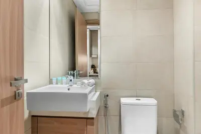 a bathroom with a white sink and a toilet at Luxury Apartments in Meydan in Dubai