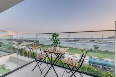 a table and chairs on a balcony with a view at Luxury Apartments in Meydan in Dubai