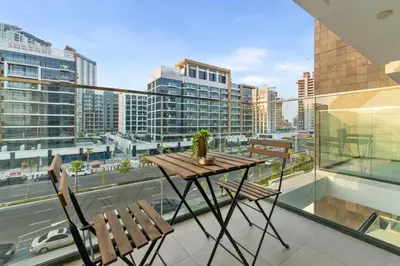 a table and chairs on a balcony with a view of a city at Luxury Apartments in Meydan in Dubai