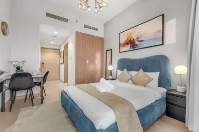 a bedroom with a large bed with a blue headboard at Luxury Apartments in Meydan in Dubai