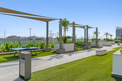 a park with picnic tables and benches on the grass at Luxury Apartments in Meydan in Dubai