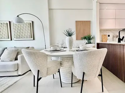 a dining room with a white table and chairs at Cloud Level 1BR Calm with Parking Pool & Gym in Dubai