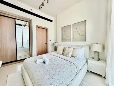 a white bedroom with a large bed and a window at Cloud Level 1BR Calm with Parking Pool & Gym in Dubai