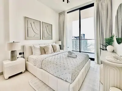 a white bedroom with a bed and a large window at Cloud Level 1BR Calm with Parking Pool & Gym in Dubai