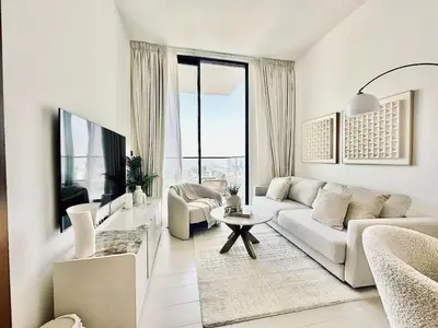 a white living room with a couch and a table at Cloud Level 1BR Calm with Parking Pool & Gym in Dubai