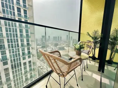 a balcony with two chairs and a table on a building at Cream Toned 1BR Suite with Parking Pool & Gym in Dubai