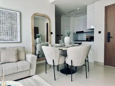 a kitchen and dining room with a table and chairs at Cream Toned 1BR Suite with Parking Pool & Gym in Dubai