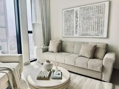 a living room with a couch and a coffee table at Cream Toned 1BR Suite with Parking Pool & Gym in Dubai