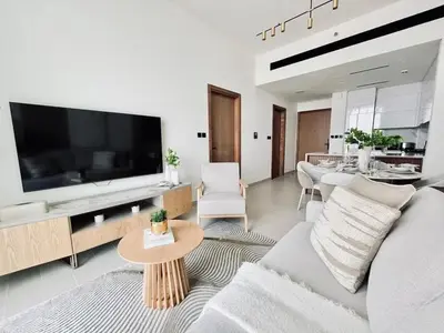 a living room with a large television and a couch at Chic 1BR with free Pool & Gym - Near Mall of Emirates in Dubai