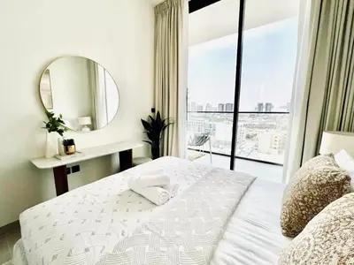 a bedroom with a bed with a mirror and a window at Chic 1BR with free Pool & Gym - Near Mall of Emirates in Dubai