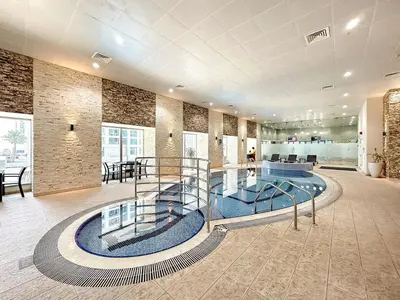 a lobby with a glass staircase in a building at FIRST CLASS 1BR High Floor Luxury & Palm View in Dubai