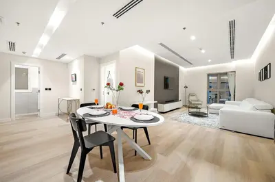 a white living room with a table and chairs at FIRST CLASS 1BR High Floor Luxury & Palm View in Dubai