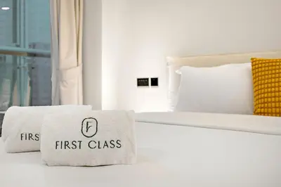 a white bed with first class pillows on it at FIRST CLASS 1BR High Floor Luxury & Palm View in Dubai