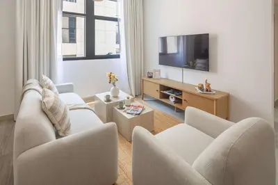a living room with two chairs and a flat screen tv at Frank Porter - Claren Tower 2, Downtown in Dubai