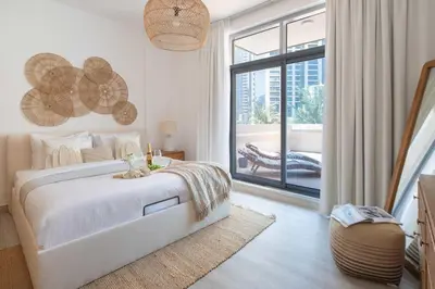 a white bedroom with a bed and a large window at Frank Porter - Claren Tower 2, Downtown in Dubai