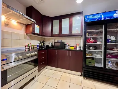 a kitchen with brown cabinets and an open refrigerator at Simbad Friendly Coliving in Dubai