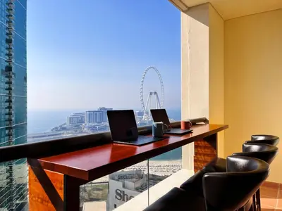 a desk with two laptops on it in front of a window at Simbad Friendly Coliving in Dubai